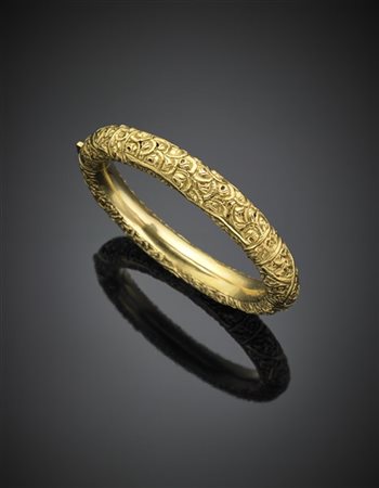 Bracciale rigido in oro giallo con motivo a rilievo, g 26,60 circa. Marcato F.