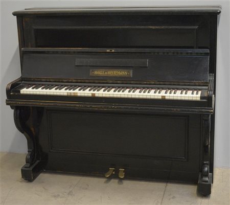 Holtzl & Heitzmann. Pianoforte verticale con cassa ebanizzata e montanti mossi.