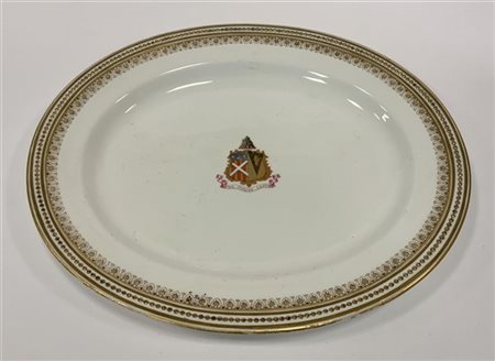 Vassoio ovale in ceramica decorato con un bordo perlato e dorato. Al centro ste