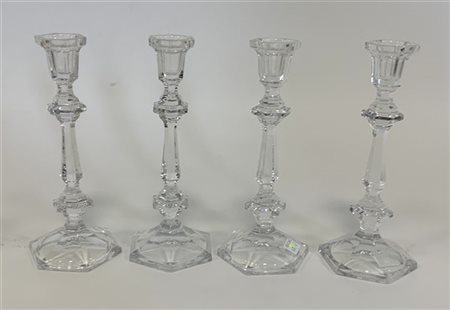 Lotto composto da quattro candelieri in vetro su basi esagonali (h. 26 cm)
