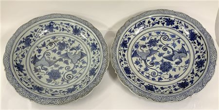 Coppia di grandi piatti in porcellana bianca e blu con profilo sagomato, decoro