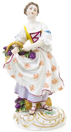 Statuetta in porcellana di Meissen, inizi XX Secolo. Donna con cesto d’uva. H...