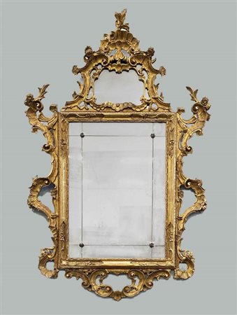 Specchiera in legno intagliato e dorato con cimasa e fregi laterali a volute, f