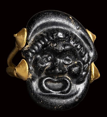 A rare roman black glass cameo  set in an ancient gold ring.  Theatrical mask. 