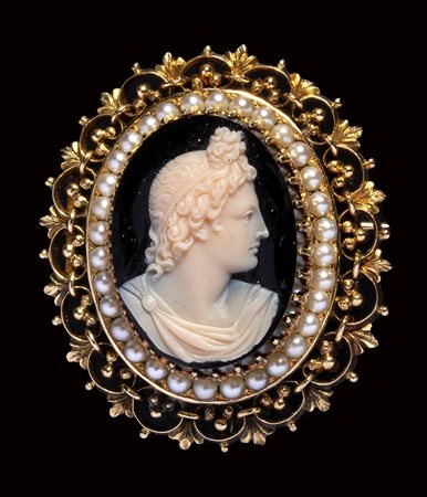 A neoclassical onyx cameo set in a gold brooch with pearls. Bust of Apollo.