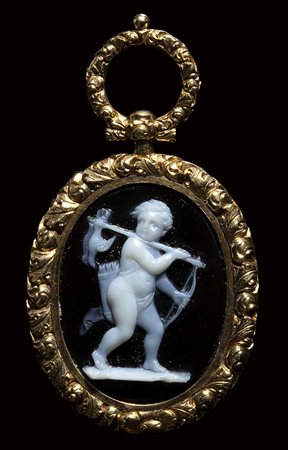 A fine neoclassical onyx cameo set in a chiseled gold pendant. Cupid hunter. 