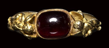 A modern gold ring with a garnet stone. 