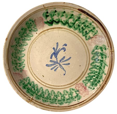 Piatto in maiolica di Caltagirone, XX Secolo. Decorato con fiore. Cm 33