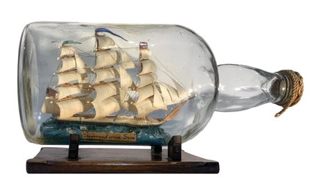 Veliero in bottiglia di vetro, con base di legno. XX secolo. Cm 20x37.
