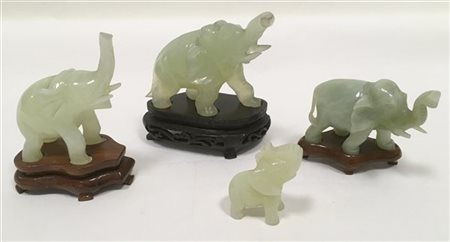Lotto di quattro elefanti in pietra dura e vetro di cui tre con base lignea (di