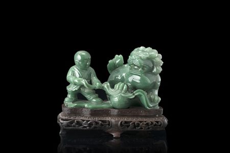 Scultura in giadeite di colore verde raffigurante bambini che giocano con leone