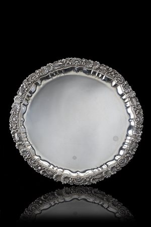 Salver in argento con tesa cesellata a valva di conchiglia e motivi stilizzati.