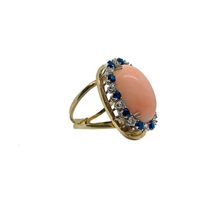 Anello in oro giallo con corallo rosa Deep sea ovale e giro in oro bianco con brillanti e zaffiri blu