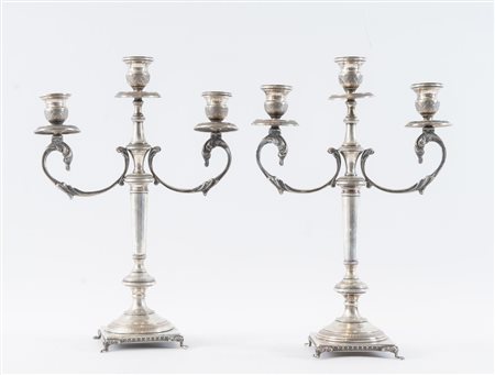 ITALIA, XX secolo. Coppia di candelabri in argento 800. Sulla base recano...