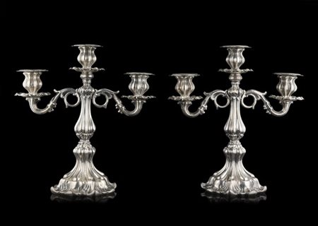 Coppia di candelabri a tre luci in argento con braccia sagomate. Fusto e bobech