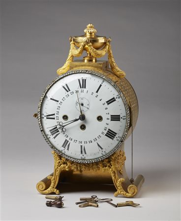  MANIFATTURA AUSTRIACA DEL XIX SECOLO - Orologio da tavolo in bronzo dorato con decorazioni dall'antico e fitomorfe, poggiante su piedi a ricciolo.