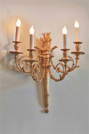 Serie di 12 appliques in bronzo dorato a quattro fiamme sorrette da una...