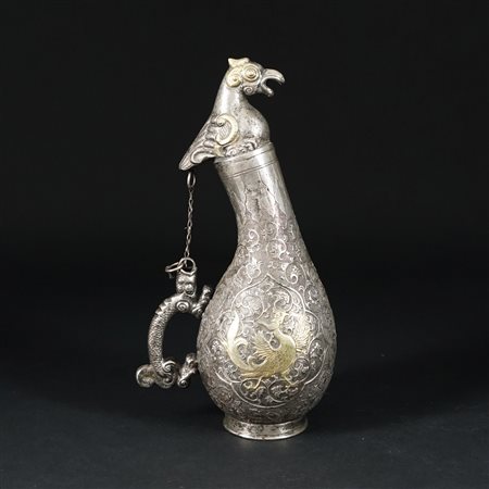 Fiasca in argento caratterizzata da una figura di fenice in argento dorato...