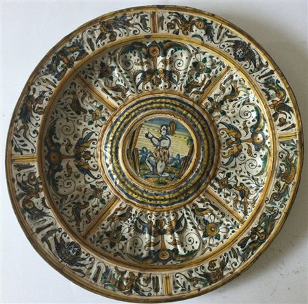 Piatto in maiolica dipinto in policromia con grottesche, cavetto baccellato cen