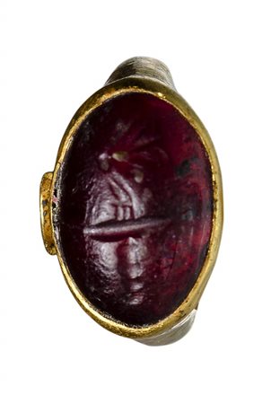 A late hellenistic gold ring with garnet intaglio. Butterfly with a torch.