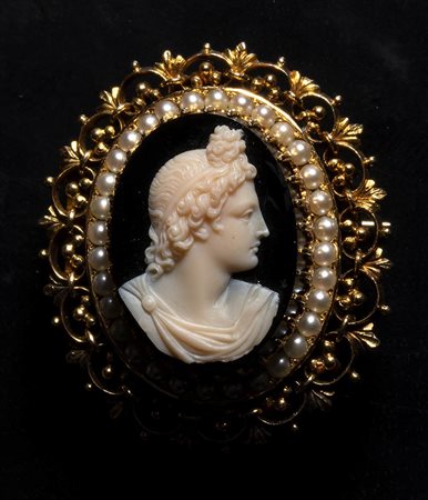 A neoclassical onyx cameo set in a gold brooch with pearls. Bust of Apollo. 