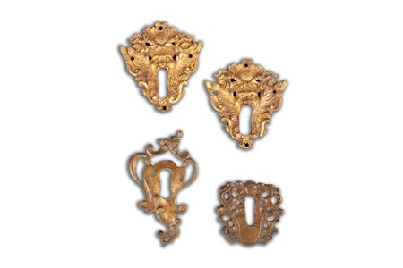 Lotto composto da quattro bocchette di serratura in bronzo, due dorate a forma di mascheroni, secoli XVII - XVIII