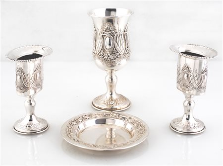  
Lotto composto da quattro accessori liturgici in argento 
 altezza cm 14,5 - diametro del piattino cm 11,5 - la coppia di bicchierini cm 11 - peso complessivo gr. 262