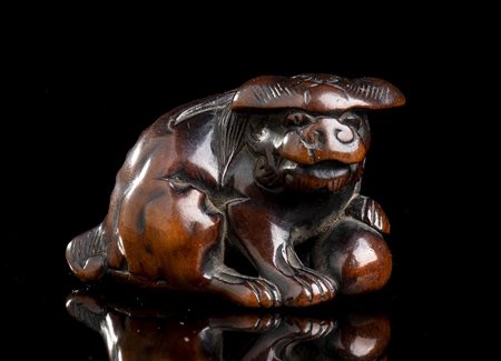 NETSUKE IN LEGNO DI BOSSO CON SHISHI 
Giappone, XIX secolo