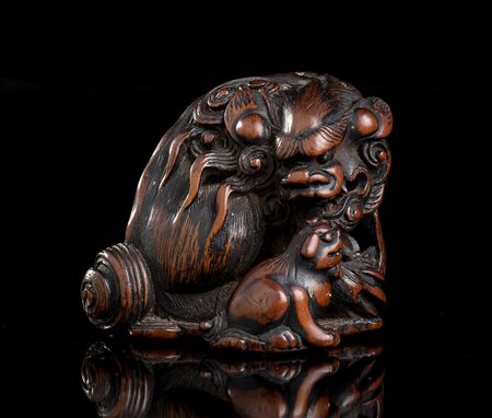 NETSUKE IN LEGNO DI BOSSO CON SHISHI 
Giappone, periodo Edo, prima metà del XIX secolo