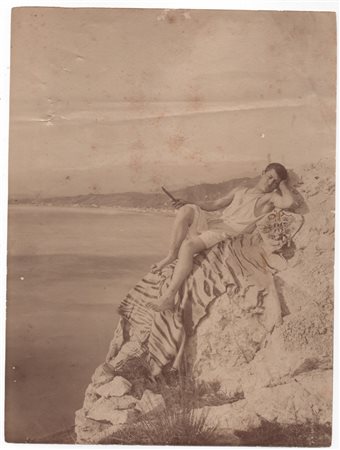 Von Gloeden, Wilhelm (Wismar1856-Taormina  1931)  - Ragazzo sdraiato sugli scogli con panorama di Giardini Naxos