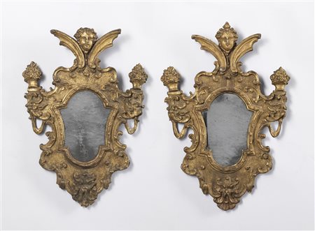 MANIFATTURA DEL XVIII SECOLO  - Coppia di ventole in legno intagliato e dorato, cornice di forma sagomata ornata a motivi di fiori e fitomorfi a rilievo, con volti di putti e mascheroni.