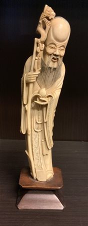 Figura di shoulao reggente pesca, base in legno
Cina, inizi sec. XX (h. cm 26,3