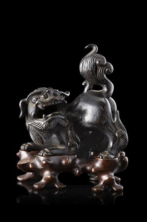 Leone buddhista in bronzo, base in legno
Cina, secolo XIX
(h. 10,5 cm.)