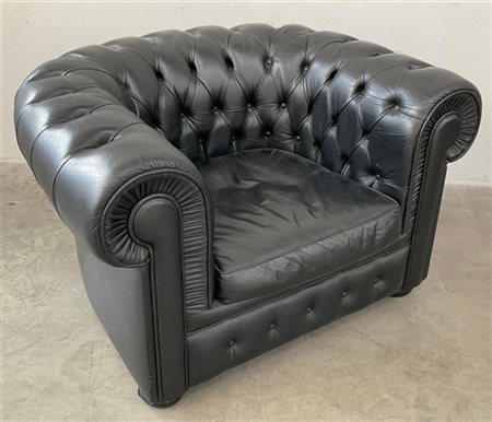 Poltrona "Chesterfield" imbottita e rivestita in pelle nera. Anni '70. (cm 110x