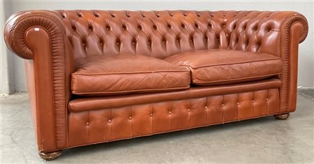 Divano "Chesterfield" a due posti imbottito e rivestito in pelle color cognac.