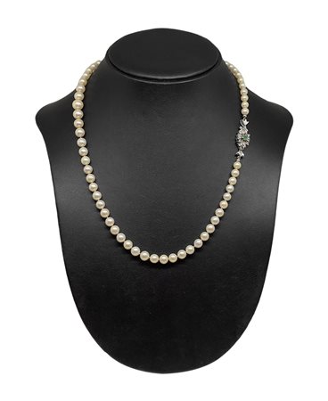 Collana di perle con chiusura in oro bianco e smeraldo centrale.