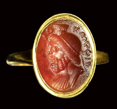 A fine roman carnelian intaglio mounted in a modern gold ring. Bust of Serapis with greek inscriptions. 2nd - 3rd century A.D.