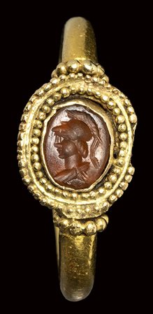 A roman carnelian intaglio set in an ancient gold ring. Bust of Athena. <br><br>3rd century A.D.