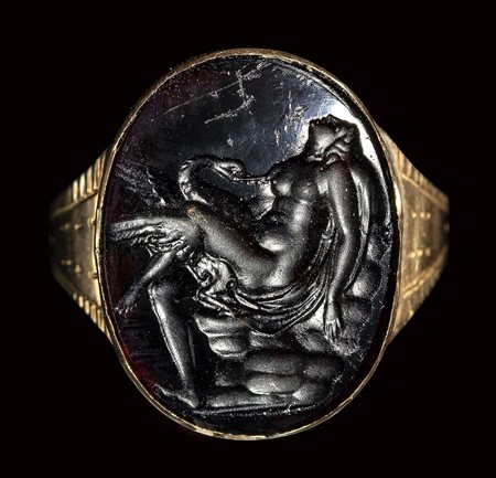 A dark glass Tassie impression set in a gold ring. Leda and the Swan.<br><br>18th - 19th century.