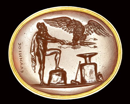 A fine neoclassical Poniatowski  carnelian intaglio signed Hellenios, set in a gold frame. Hephestus giving the thunderboalt to Zeus's eagle. 19th century.