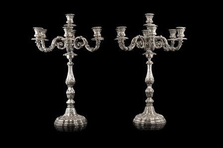 Coppia di candelabri a sette fiamme in argento sbalzato a volute e decori fogli