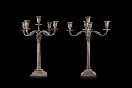 Coppia di candelabri in argento a cinque fiamme, basi quadrate, fusti scanalati