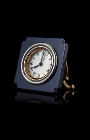 CARTIER
Orologio da comodino di forma quadrata in ottone e lacca. Quadrante a c