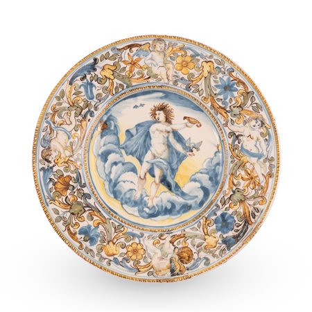  
Castelli, bottega di Francesco Grue. Piatto in maiolica decorato con girali fogliati, fiori e putti sulla tesa e con scena mitologica nel cavo.  Seconda metà del XVII secolo
 Ø cm 24