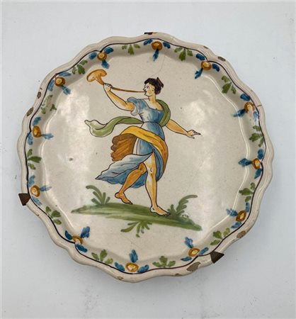 Alzata in maiolica a bordo sagomato decorata nella falda a motivi vegetali e ne