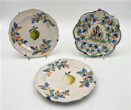 Manifatture differenti. Lotto di tre piatti in maiolica a bordo sagomato. Due d