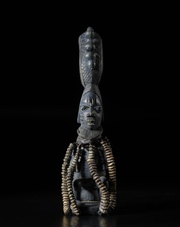  Arte africana - Nigeria, Yoruba. 
Figura di Eshu.
Legno con patina scura, cauri e cuoio. 
Prima metà del XX sec. .