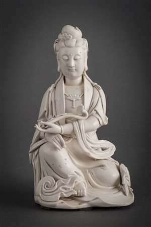 Scultura in porcellana blanc-de-chine raffigurante Guanyin seduta con lo scettr