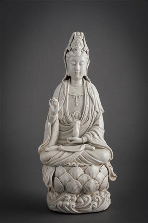 Scultura in porcellana blanc-de-chine raffigurante Guanyin sul loto, con in man