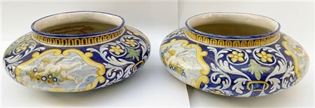 Coppia di cache-pot in ceramica policroma con decoro a putti e volute fiorite s